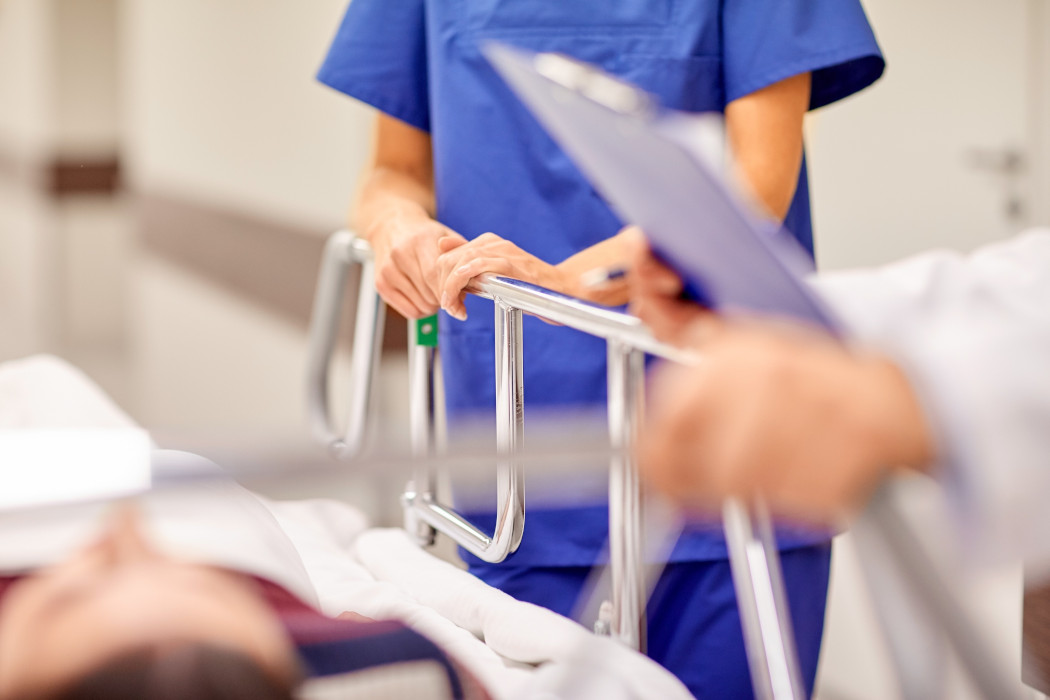 Doctor and Nurse standing next to patient in a hospital bed